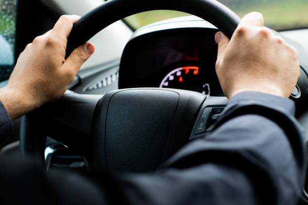istock man's hand on steering wheel, driving a car Selective focus 1202698192