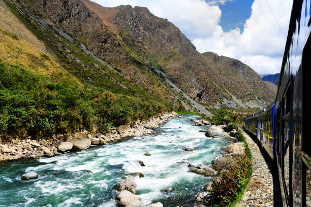 Peruvian train to Machu Picchu along the Urubamba River Peruvian train to Machu Picchu along the Urubamba River. urubamba province stock pictures, royalty-free photos & images