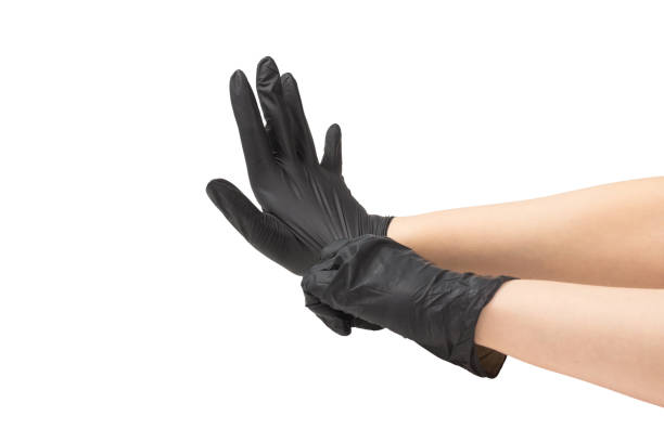 istock Woman puts on black rubber gloves. 1202698630