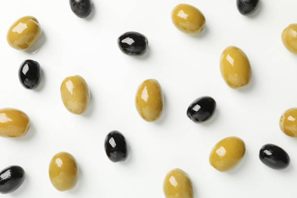 Green and black olives on white background, top view