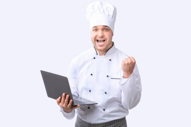 istock Excited Cook Guy Holding Laptop Gesturing Yes, Studio Shot 1202700316