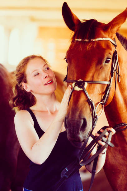 istock Woman hugging brown horse in stable 1202700374