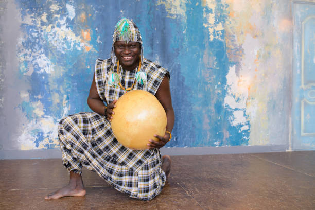 homme africain bel avec des vêtements traditionnels et des instruments de musique - nigeria african culture dress smiling photos et images de collection