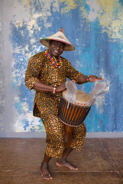istock Handsome african drummer weared in traditional costume playing on djembe drum 1202700606