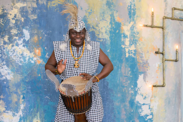 istock African artist in traditional clothes playing djembe drum 1202700612
