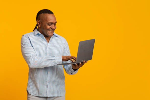 istock Modern mature african man surfing on internet on laptop 1202700642