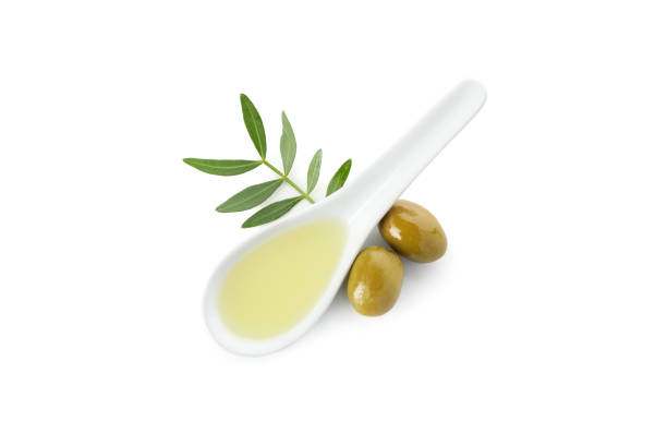 istock Ceramic spoon with olive oil, olives and leaves isolated on white background 1202702302