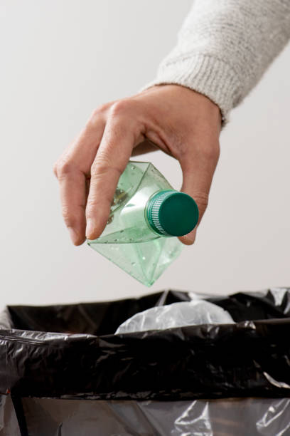 istock man throwing a plastic bottle to the trash bin 1202702482