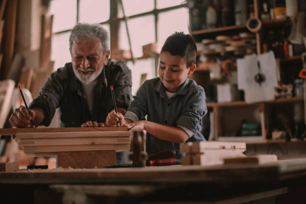 istock Senior carpenter and his grandson having fun in the workshop 1202703357