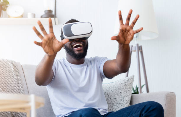istock Emotional african man enjoying augmented reality at home 1202703770