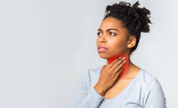 Black woman suffering from sore throat, touching her neck Young black girl suffering from pain in throat, touching inflamed red zone on her neck, panorama with empty space follicular thyroid cancer stock pictures, royalty-free photos & images