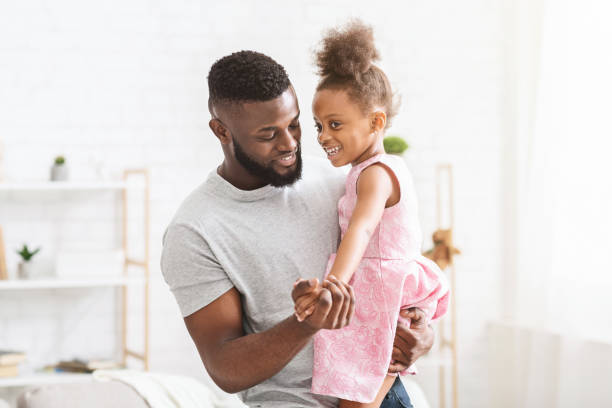 istock Young black father holding little daughter, dancing together 1202705049