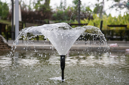 Glass and circular futuristic water fountain in San Francisco during springtime day