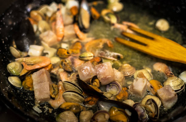 les pêcheurs préparent un petit déjeuner traditionnel de fruits de mer - seafood lobster paella prepared shellfish photos et images de collection