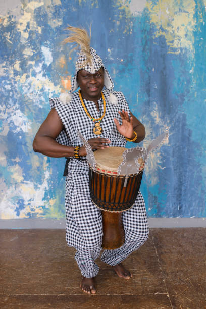 istock African artist in traditional clothes playing djembe drum 1202707232