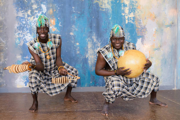istock African artists with traditional musical instruments on blue wall background. 1202707836