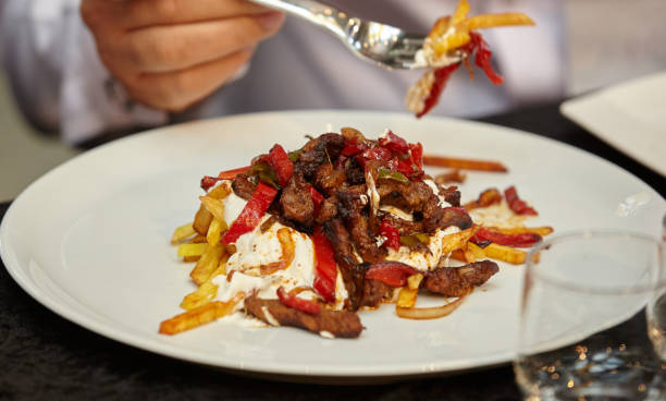 istock Fried meat with vegetables. Potatoes with sauce and meat.Pricks with a fork 1202708236
