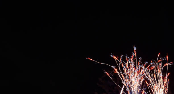 Red and gold streaming wheat shaped fireworks with white accents with a black background