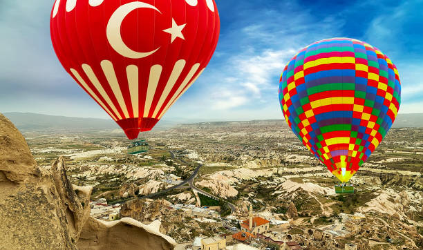 Mountain landscape Hot air balloon flying over Cappadocia Turkey. Turkish flag Ottoman Empire star and crescent.