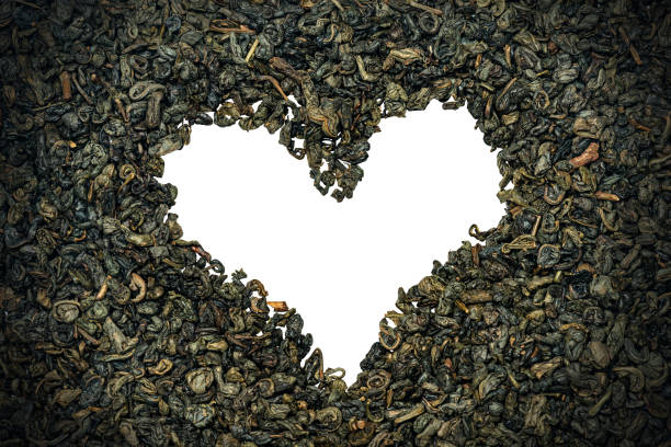 folhas secas de chá de pólvora verde dispostos em forma de coração - heart shape isolated isolated on white tea leaves - fotografias e filmes do acervo