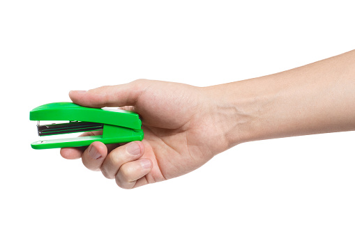 Hand holding a green stapler, isolated on white background