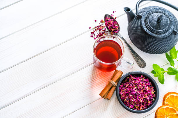 Rose petals tea shot on white table. Copy space