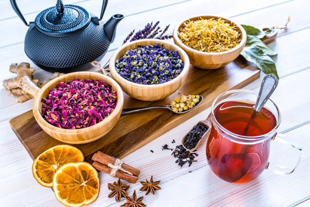 istock Herbal tea cup with various multi colored dried tea leaves and flowers shot on white table 1202719647