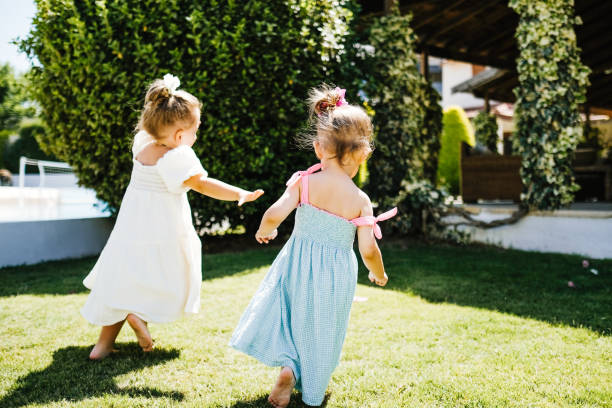 istock Two little girls having fun and running together 1202720879