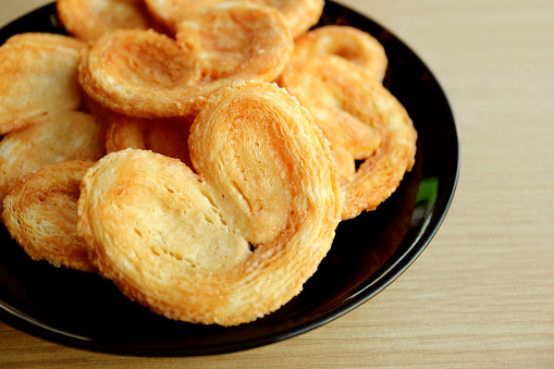 Closeup a Plate of  French Palmier Pastries on Wooden Table