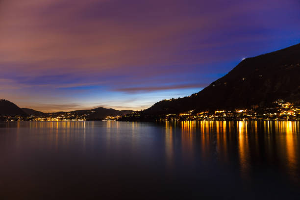 закат и иллюминация прекрасной вечерней панорамы озера комо. италия, ломбардия - lake como water italy sunset стоковые фото и изображения