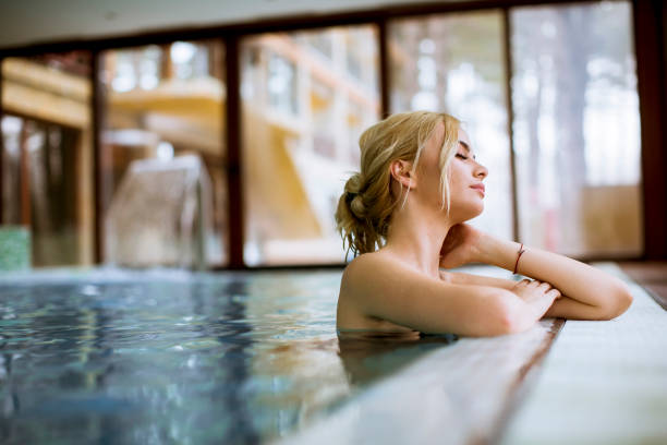 istock Young woman relaxing in spa swimming pool 1202722573