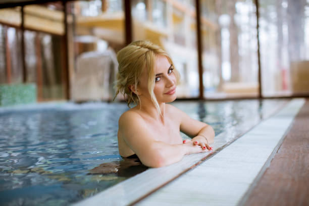 istock Young woman relaxing in spa swimming pool 1202722593