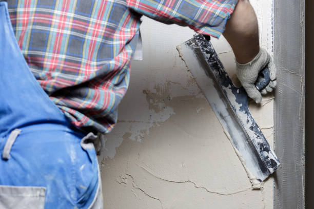 istock Construction worker puts a gypsum on the wall with a spatula 1202722728