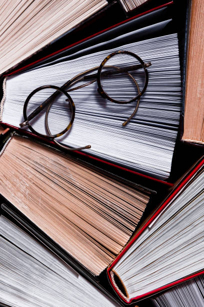 istock Lots of colourful thick open books stand on a dark background 1202725021
