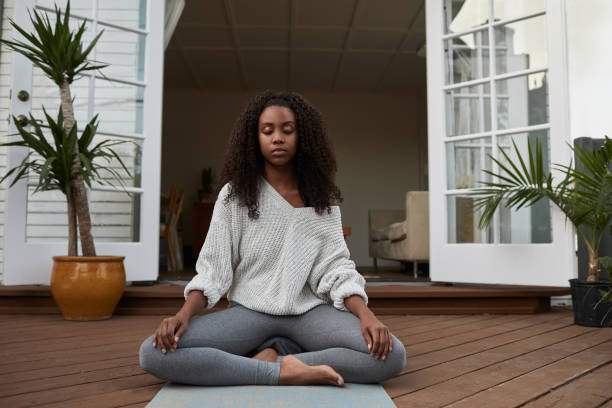istock Young woman meditating outside on her patio 1202725089
