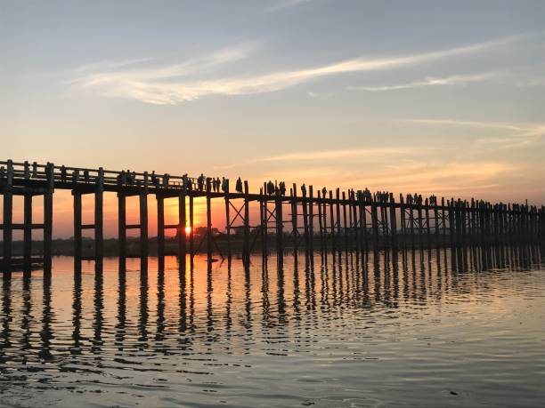 istock Silhouettes crossing U Bein bridge at sunset, Myanmar 1202725243