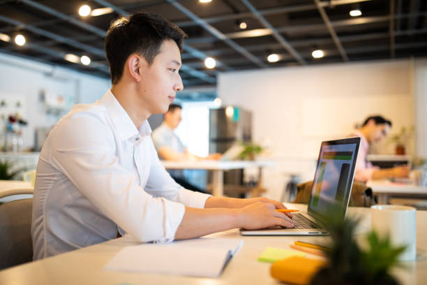 istock Young Taiwanese man using laptop at office 1202726064