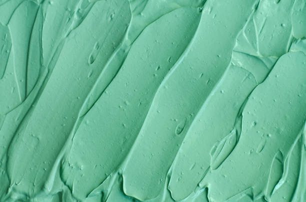 istock Green cosmetic clay (facial mask, face cream, body wrap) texture close up, selective focus. Abstract background with brush strokes. 1202726754