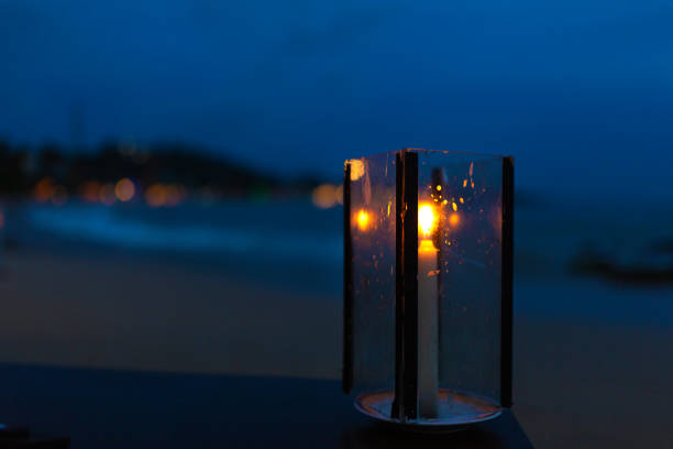 istock Oceanfront restaurant with lights and tables on a sandy beach 1202728442