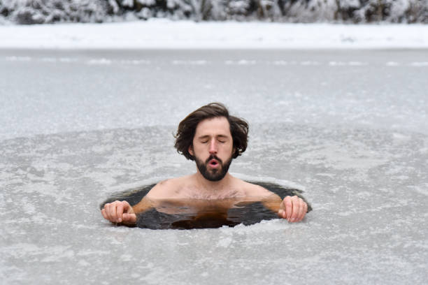 istock Young man have bath in cold water in nature and does Wim hof method 1202728656