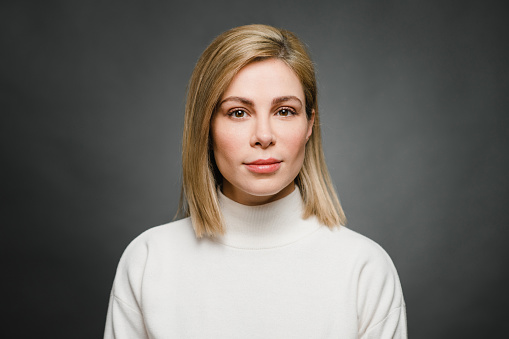 Portrait of a casual business woman in front of a grey background