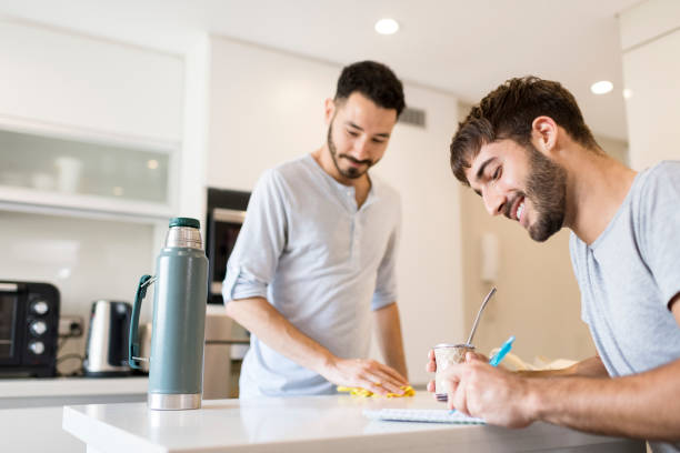 istock Young homosexual couple doing chores together 1202730333