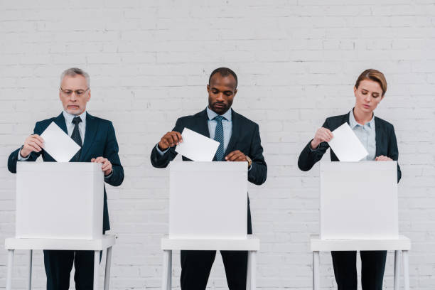istock multicultural voters putting ballots in voting boxes 1202730427