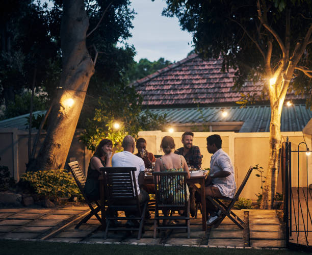 Nothing is better than food shared with friends Shot of a group of young friends having a dinner party outdoors dinner party photos stock pictures, royalty-free photos & images
