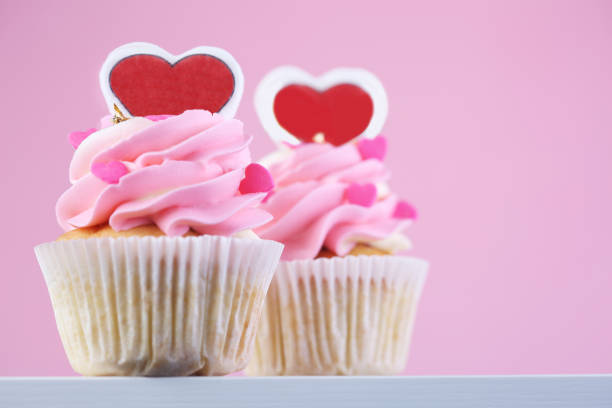 istock Cupcakes with hearts on pink background. Closeup 1202732872