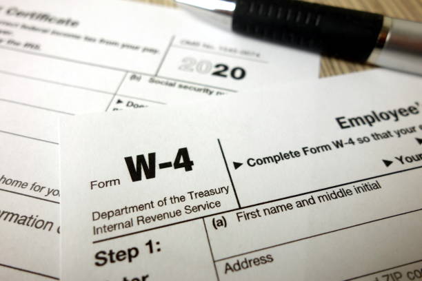 Blank W-4 form and a pen. Tax season Blank W-4 form and a pen. Tax season tax season photos stock pictures, royalty-free photos & images