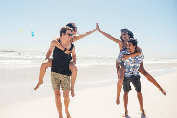 Shot of two young couples enjoying themselves at the beach on a sunny day