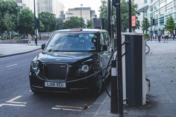 carro hackney eléctrico en la estación de carga, londres - black cab fotografías e imágenes de stock