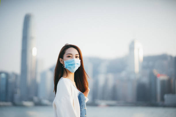 young asian woman wearing a protective face mask to prevent the spread of coronavirus, a global health emergency over outbreak - china covid imagens e fotografias de stock
