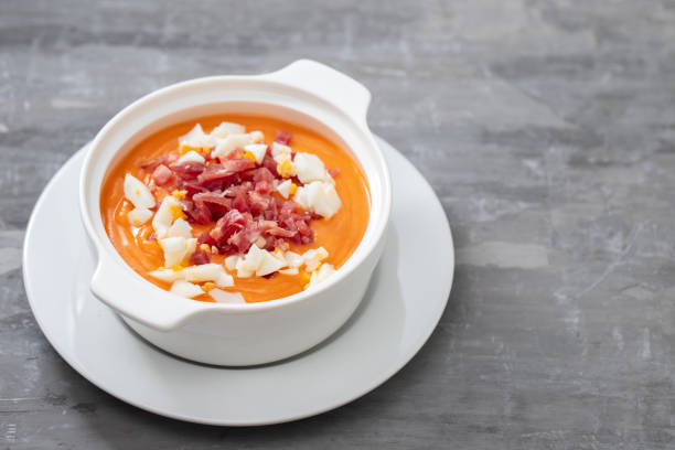 istock Typical Spanish soup salmorejo cream with ham and egg in white bowl on ceramic background. Top view. 1202739483
